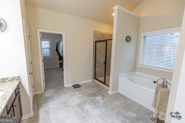 bathroom with separate shower and tub, vaulted ceiling, and vanity