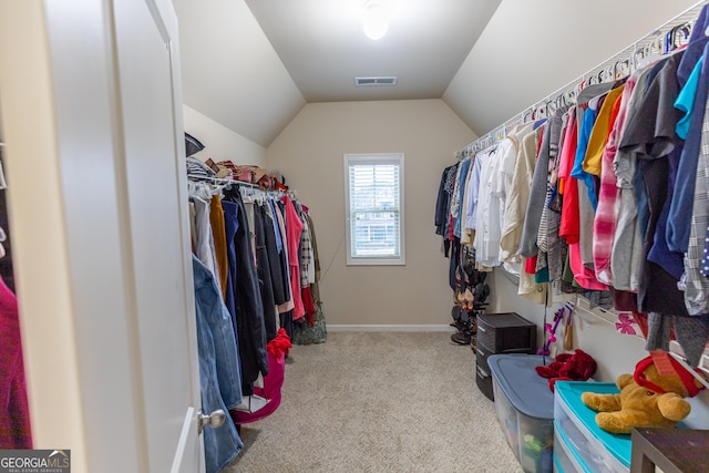 spacious closet with light carpet and vaulted ceiling