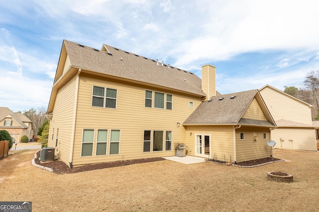 rear view of property with cooling unit, a fire pit, and a patio area