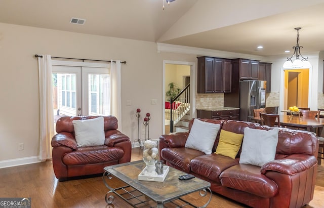 living room with french doors, vaulted ceiling, and wood-type flooring