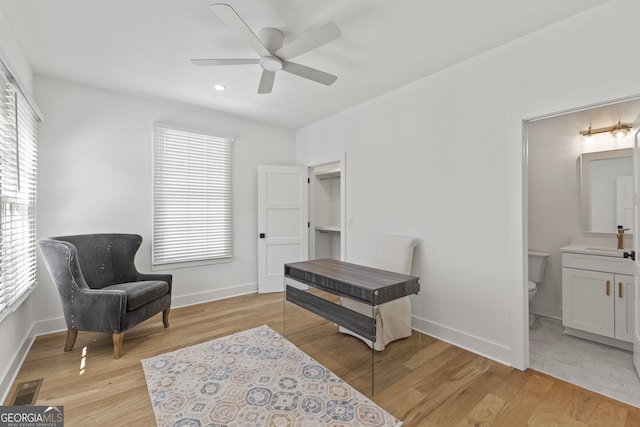 living area with ceiling fan and light hardwood / wood-style flooring