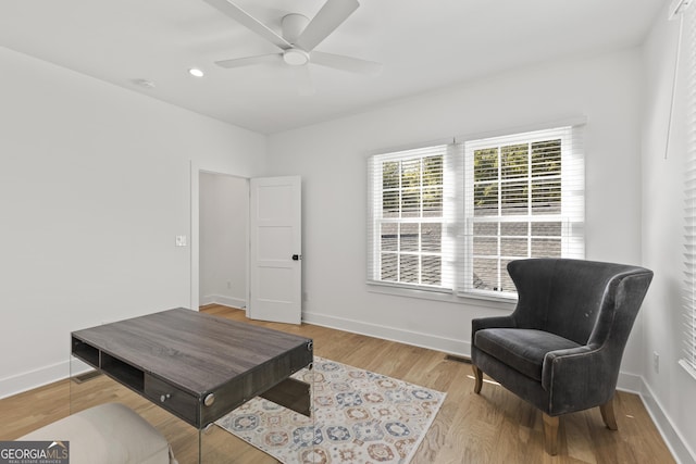 living area with ceiling fan and light hardwood / wood-style flooring