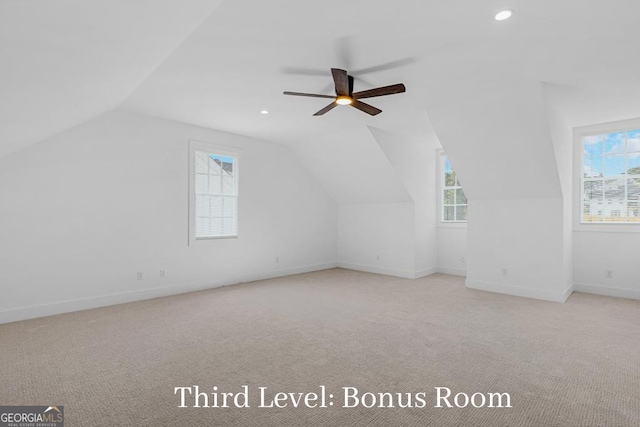 additional living space featuring ceiling fan, light colored carpet, and lofted ceiling