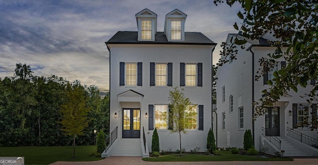 view of front of house with a yard and french doors