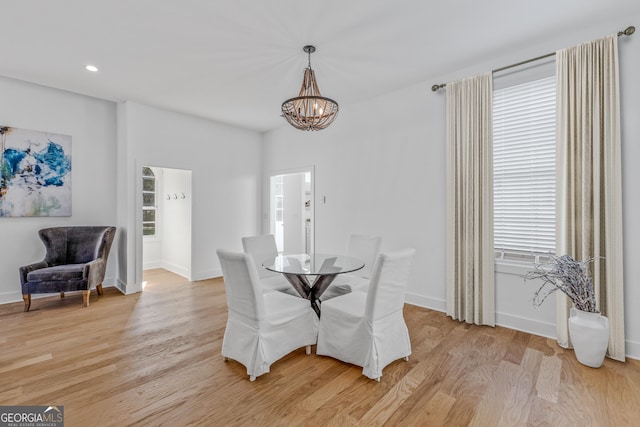 dining space with recessed lighting, light wood-type flooring, baseboards, and a notable chandelier