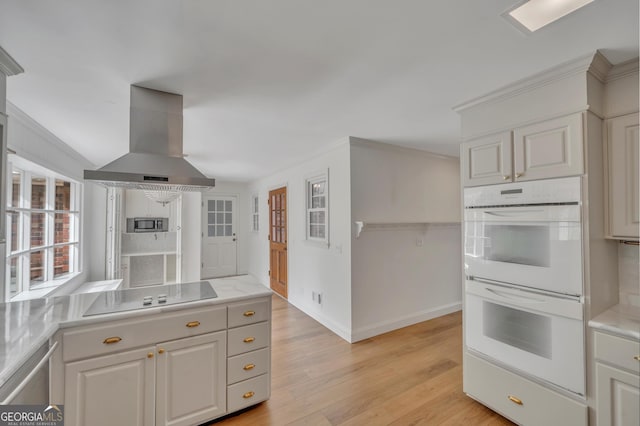 1706 Murphy Ln, Dublin, GA 31021 - kitchen featuring ventilation hood, double oven, electric stovetop, light wood-style floors, and light countertops