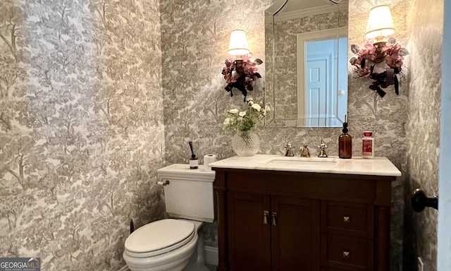 bathroom featuring ornamental molding, vanity, and toilet