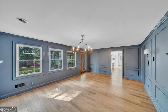 1706 Murphy Ln, Dublin, GA 31021 - unfurnished dining area with a decorative wall, a chandelier, light wood-style flooring, crown molding, and recessed lighting