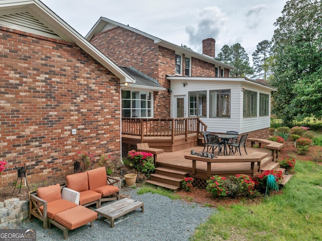 1706 Murphy Ln, Dublin, GA 31021 - rear view of house featuring a deck, outdoor lounge area, a chimney, a sunroom, and outdoor dining space