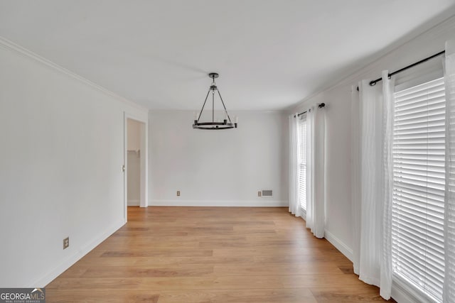 1706 Murphy Ln, Dublin, GA 31021 - unfurnished dining area with light wood finished floors, crown molding, and a chandelier