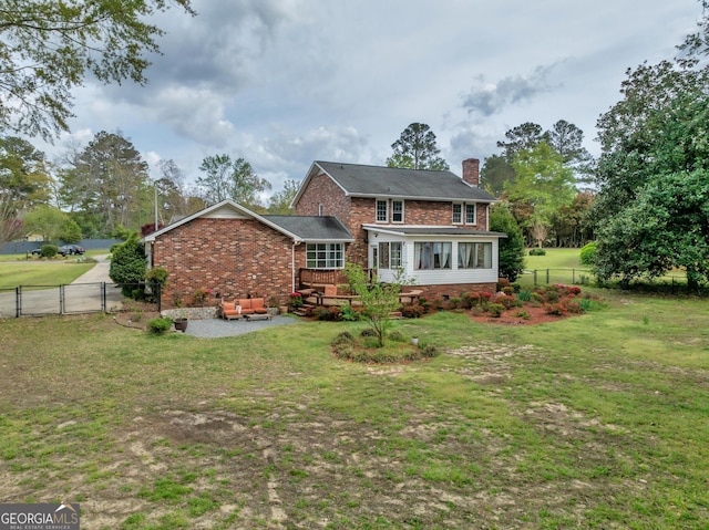 1706 Murphy Ln, Dublin, GA 31021 - back of property with a fenced backyard, brick siding, a chimney, a sunroom, and a gate