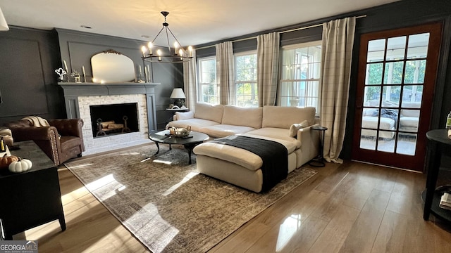 sitting room with hardwood / wood-style floors, a chandelier, and a healthy amount of sunlight