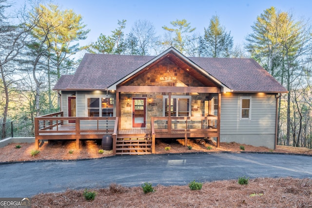 rustic home featuring roof with shingles