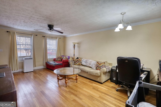 living room featuring light wood finished floors, baseboards, a textured ceiling, crown molding, and ceiling fan with notable chandelier