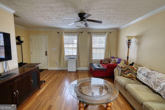 living room featuring light wood finished floors, ornamental molding, ceiling fan, a textured ceiling, and baseboards