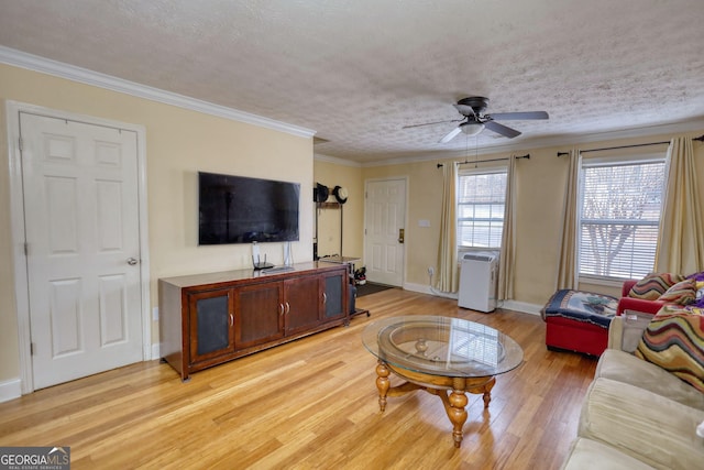 living room featuring ornamental molding, ceiling fan, a textured ceiling, light wood-type flooring, and baseboards