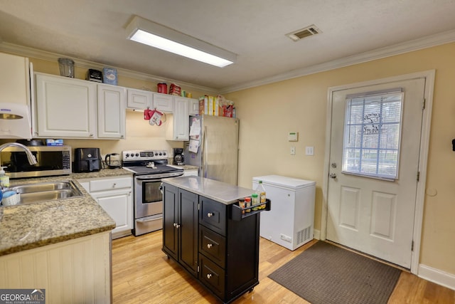 kitchen with light countertops, visible vents, appliances with stainless steel finishes, white cabinets, and a sink