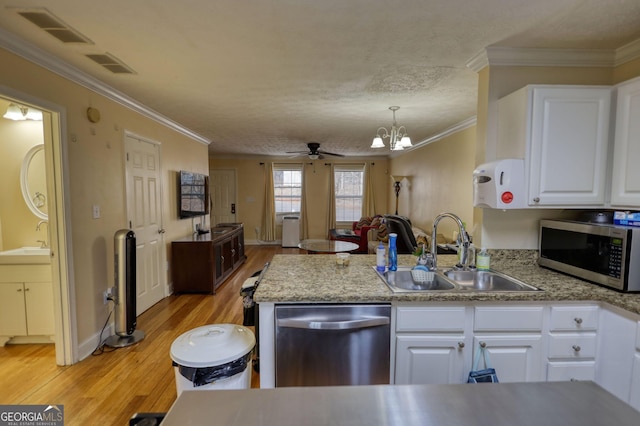 kitchen with stainless steel appliances, a peninsula, a sink, and visible vents