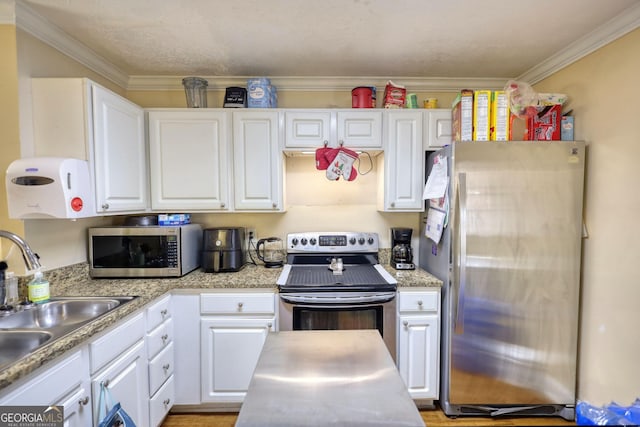 kitchen featuring stainless steel appliances, a sink, white cabinets, light countertops, and crown molding