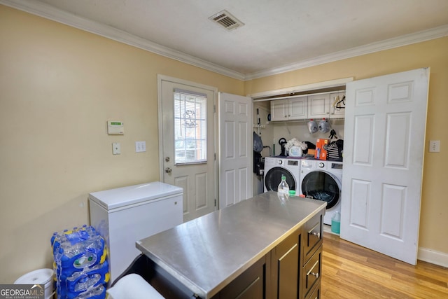 laundry area featuring laundry area, light wood finished floors, visible vents, ornamental molding, and washing machine and dryer