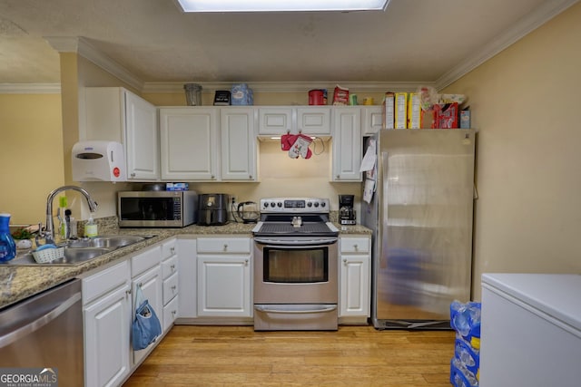 kitchen featuring light wood-style floors, white cabinetry, appliances with stainless steel finishes, and a sink