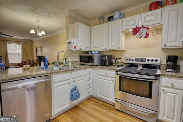 kitchen with crown molding, stainless steel appliances, light wood-style floors, white cabinetry, and a sink