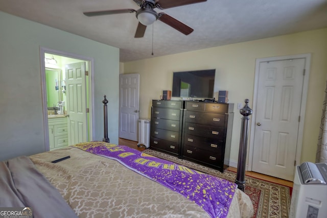 bedroom featuring wood finished floors, connected bathroom, and a ceiling fan