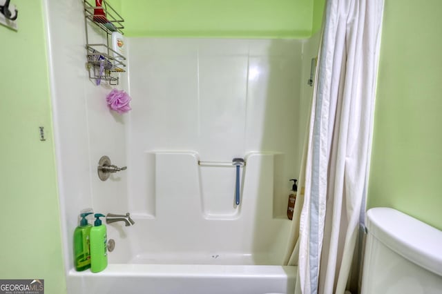 bathroom featuring shower / bath combo with shower curtain and toilet