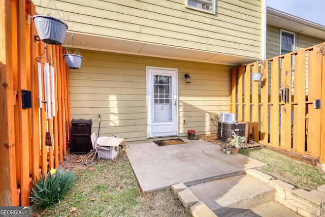 doorway to property with central air condition unit, a patio area, and fence