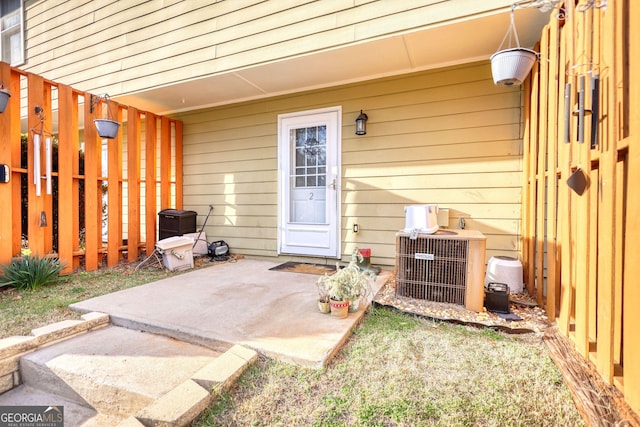 view of exterior entry featuring a patio area and central air condition unit