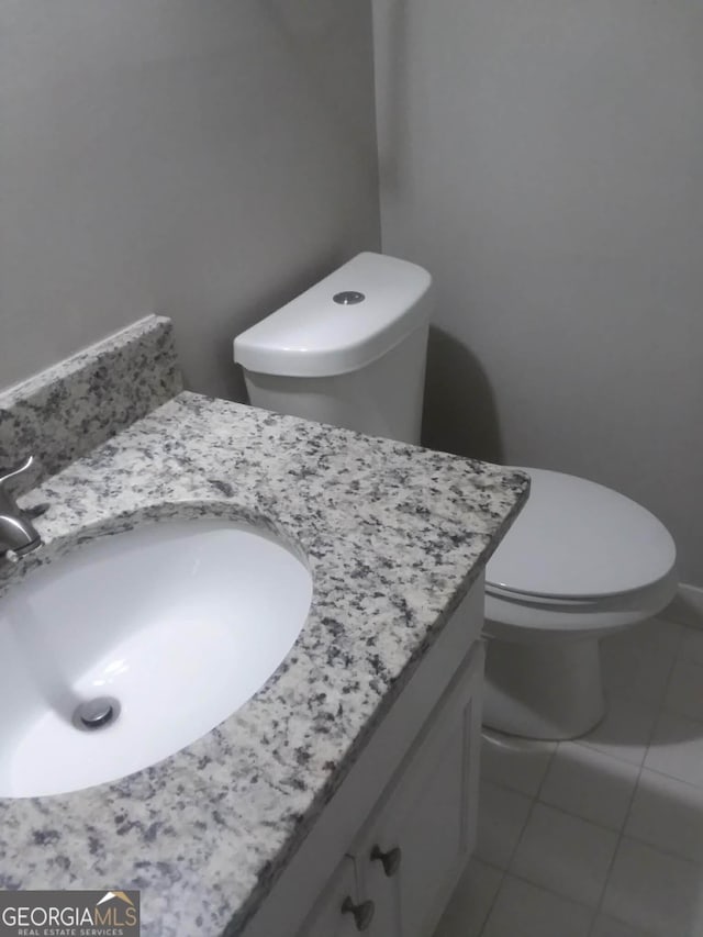 bathroom featuring tile patterned floors, vanity, and toilet