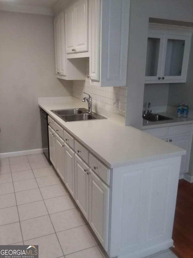 kitchen featuring sink, backsplash, black dishwasher, and white cabinets