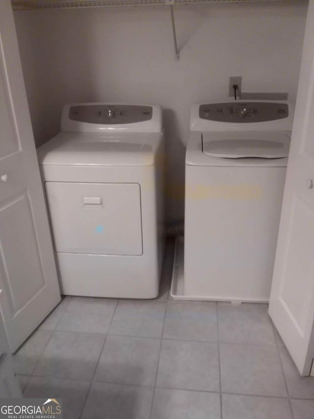 laundry area featuring separate washer and dryer and light tile patterned floors