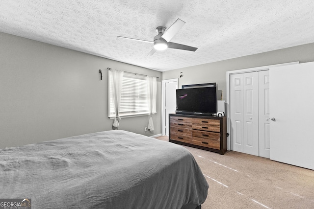 bedroom featuring ceiling fan, carpet flooring, and a textured ceiling