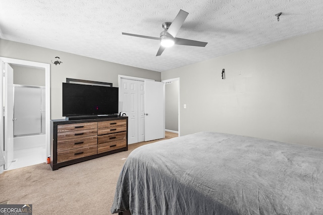 bedroom with ensuite bath, ceiling fan, carpet, a textured ceiling, and a closet