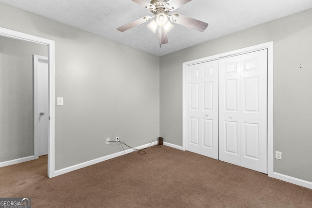 unfurnished bedroom with a textured ceiling, a closet, ceiling fan, and carpet flooring