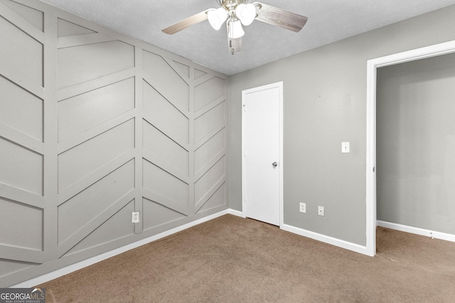 unfurnished bedroom featuring ceiling fan, carpet flooring, and a textured ceiling