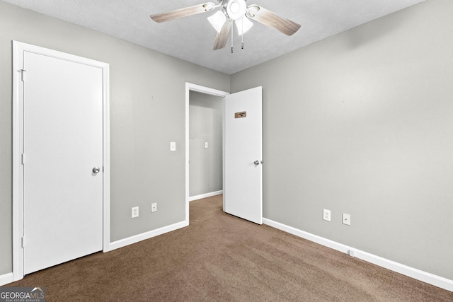 unfurnished bedroom featuring ceiling fan, carpet floors, and a textured ceiling