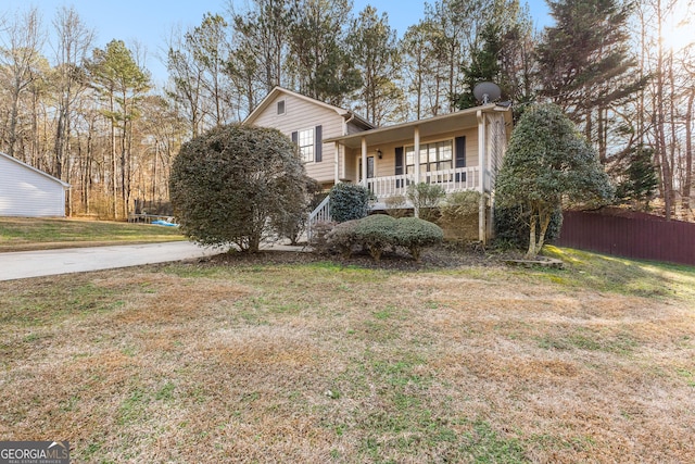 view of front of property with a porch, a front yard, and a trampoline