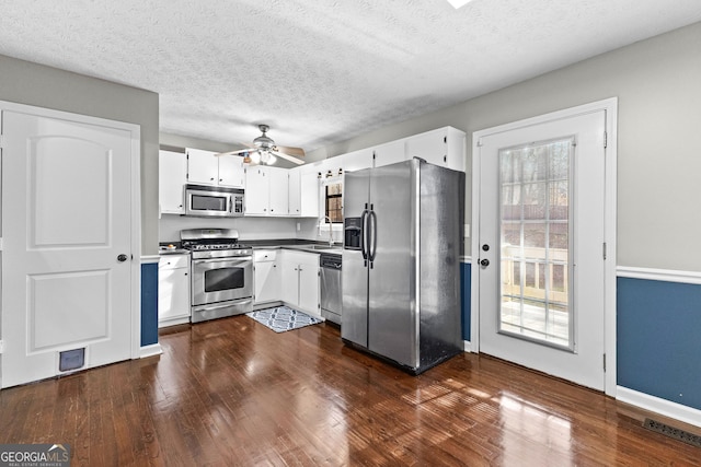 kitchen featuring white cabinetry, dark wood-type flooring, a healthy amount of sunlight, and appliances with stainless steel finishes