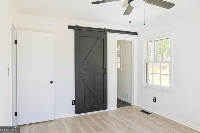 entryway featuring plenty of natural light, visible vents, light wood-style flooring, and a barn door