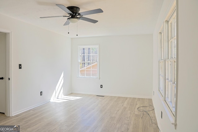 unfurnished room with light wood-type flooring, baseboards, visible vents, and ceiling fan