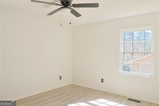 unfurnished room with light wood-style floors, visible vents, baseboards, and a ceiling fan