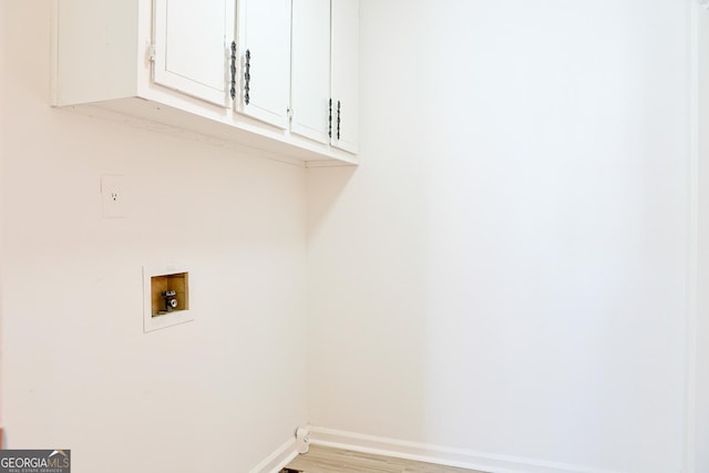 laundry room with light wood-type flooring, washer hookup, cabinet space, and baseboards