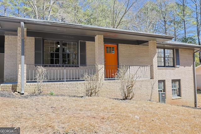 view of front of home with brick siding and a porch