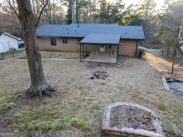 view of front of property featuring a patio area and roof with shingles