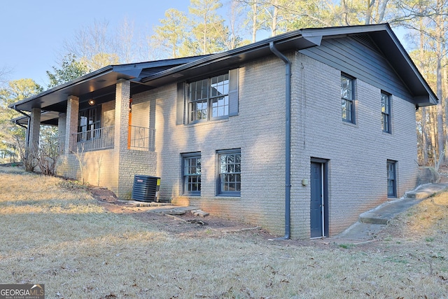 view of side of home featuring cooling unit and brick siding