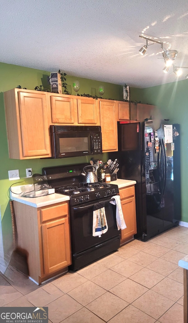 kitchen featuring light tile patterned flooring, a textured ceiling, and black appliances