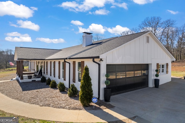 view of side of property with a garage and covered porch