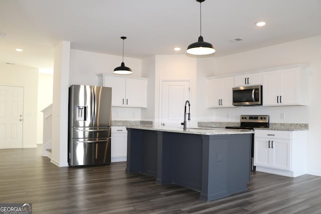 kitchen with white cabinets, stainless steel appliances, and an island with sink